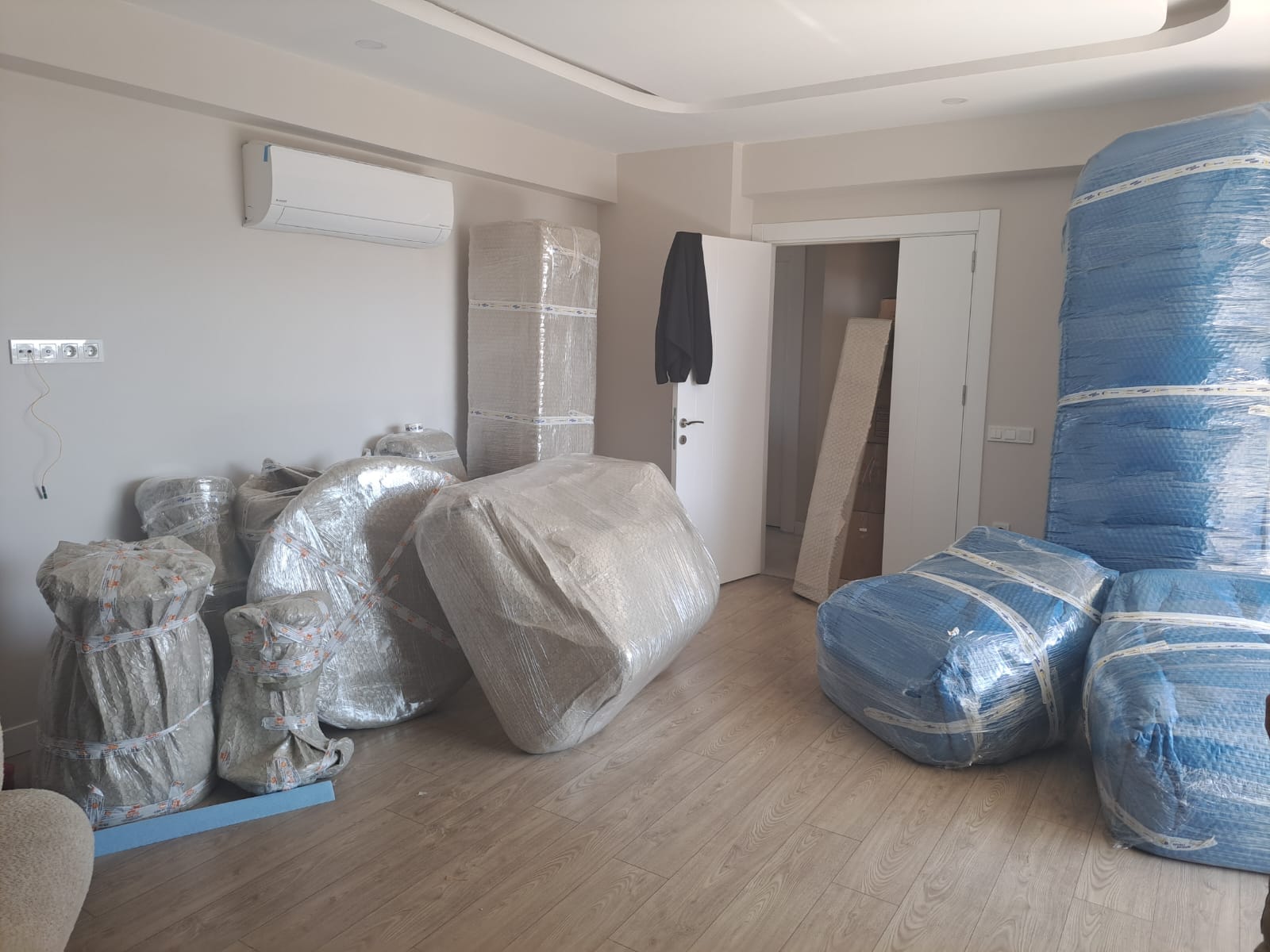 Antalya evden eve nakliyat: salonda paketlenmiş ve sarılmış mobilyalar
